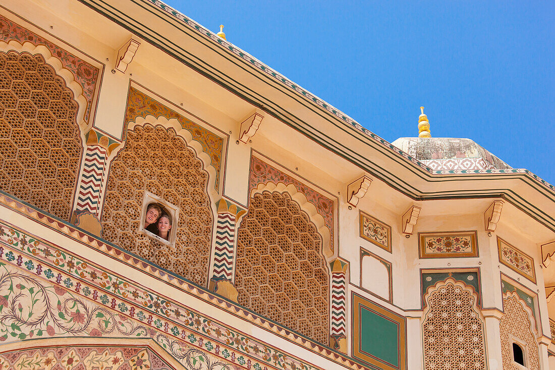 A Young Couple Looks Out A Small Window At Amer Fort; Jaipur Rajasthan India