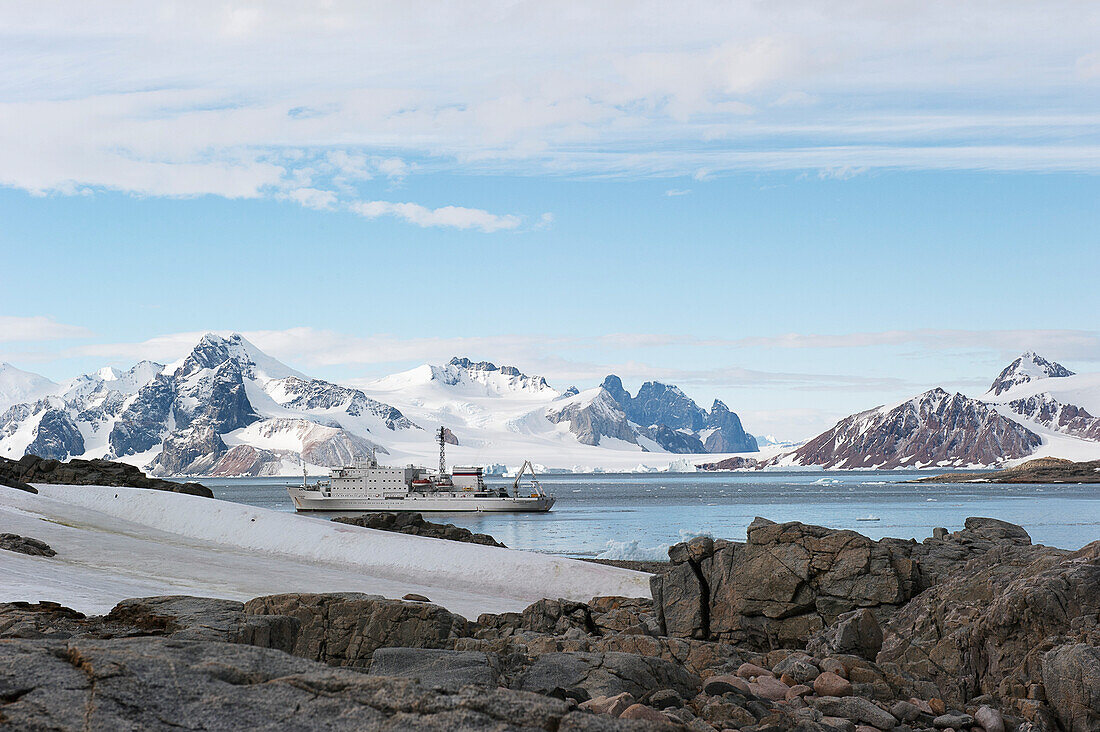 Ein Schiff fährt entlang der Küste; Antarktis