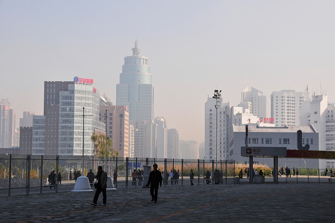 Pedestrians On A Walkway With Buildings In An Urban Area; Beijing China