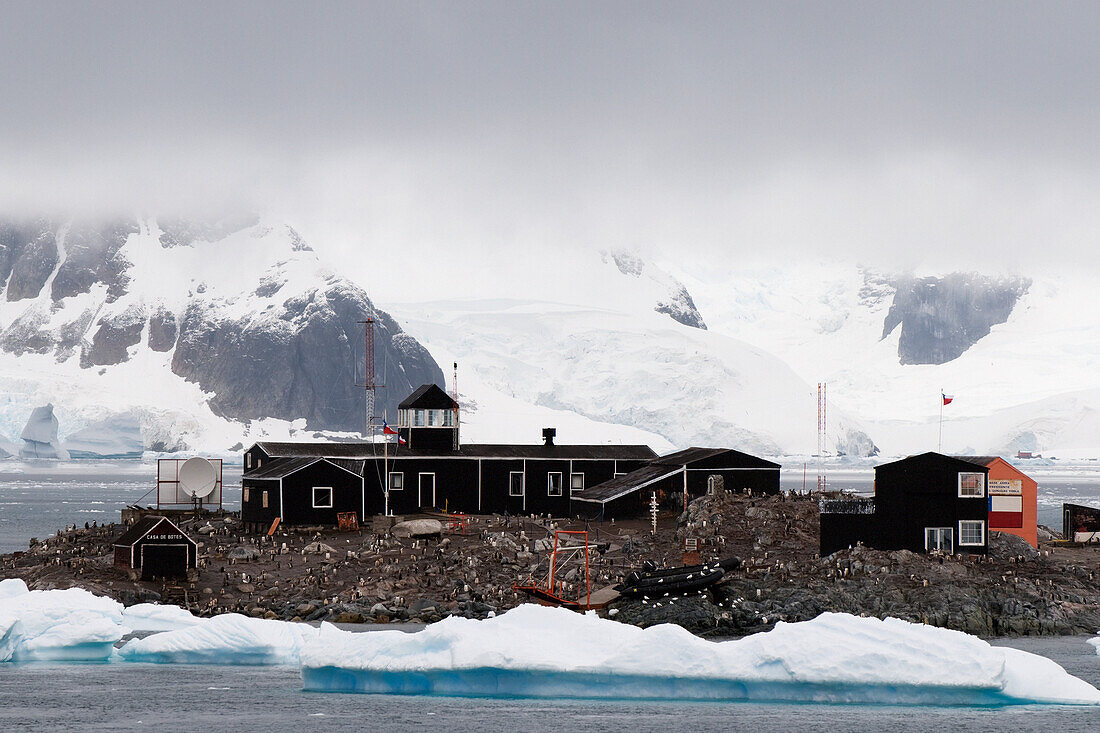 Gebäude auf einer Insel mit der gefrorenen Küstenlinie im Hintergrund; Südliche Shetlandinseln Antarktis
