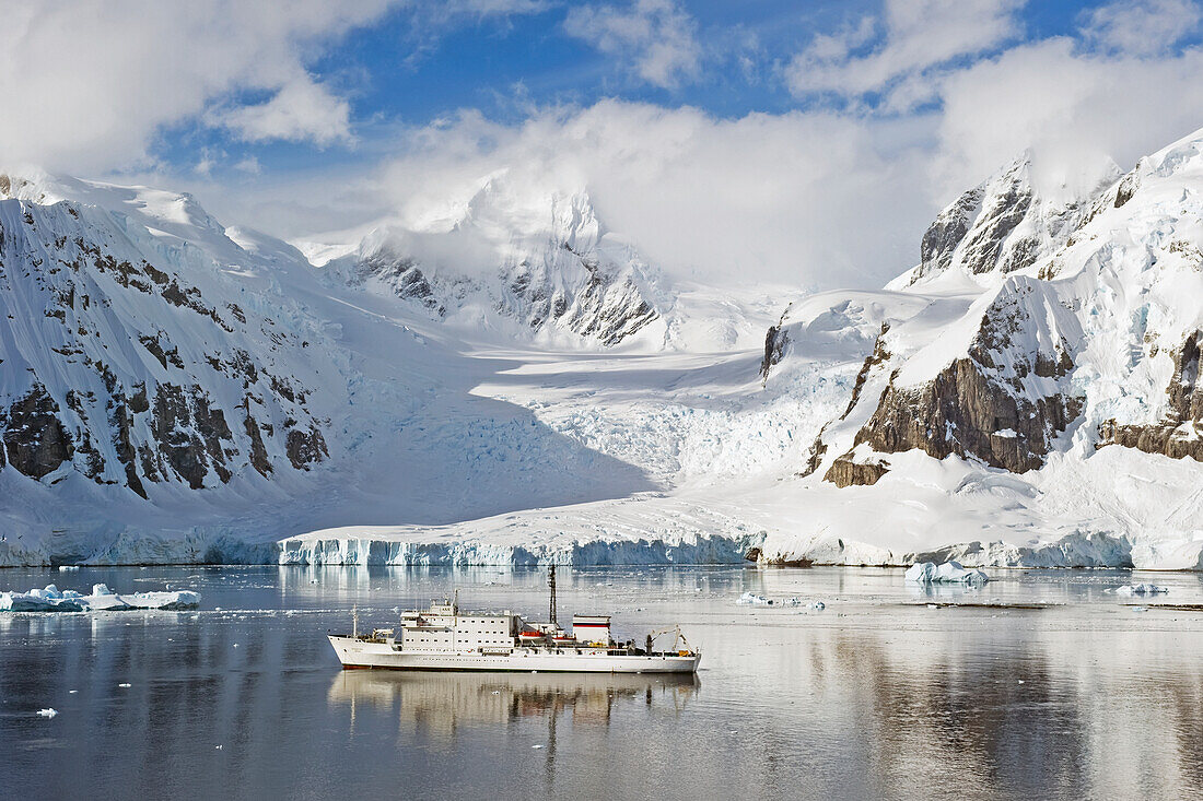 Ein Schiff segelt entlang der Küste; Antarktis