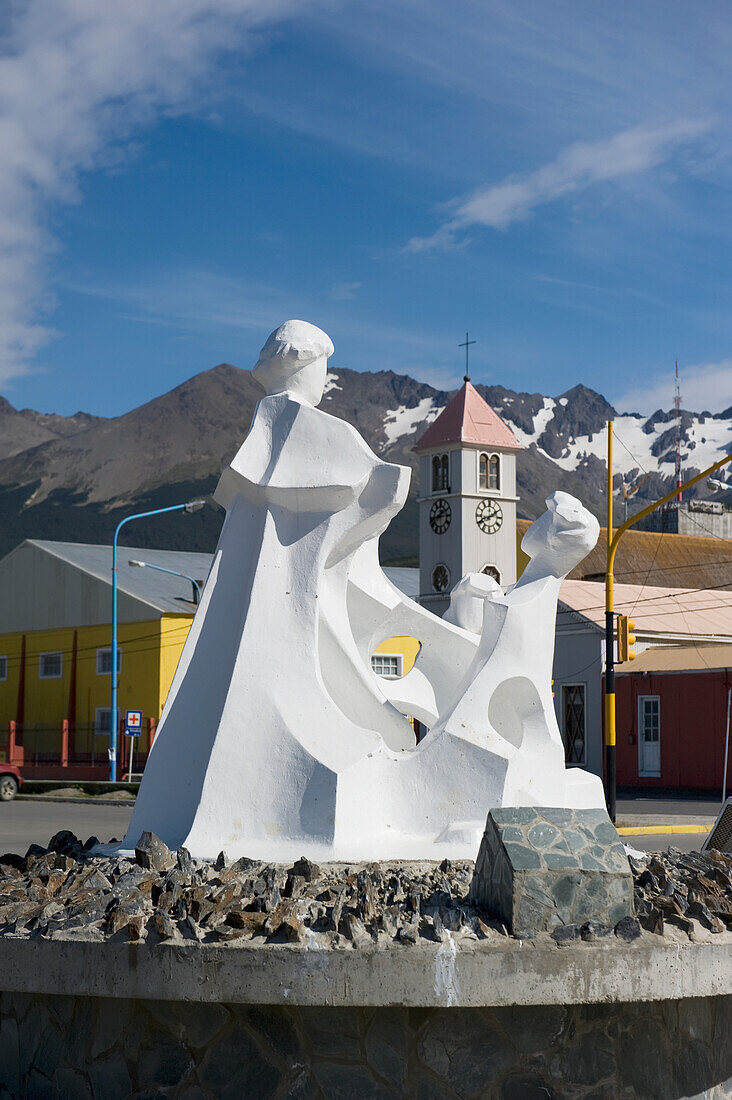 Weiße Skulpturen mit bunten Gebäuden und einem Uhrenturm im Hintergrund; Ushuaia Argentinien