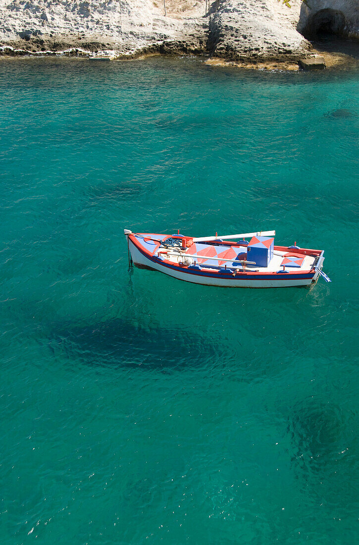Greece, Cyclades, Island of Milos, Boat off the shore of Mitakes Village.