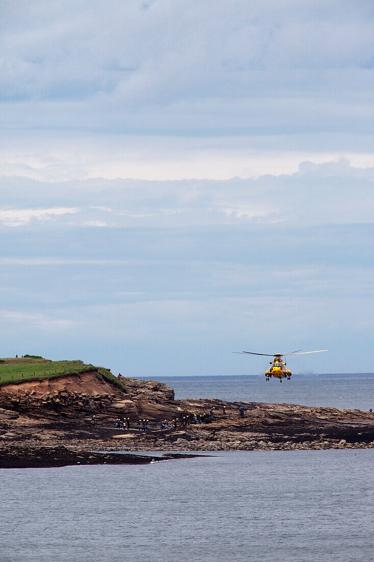 A Rescue Helicopter In Flight By The Coast; Northumberland England