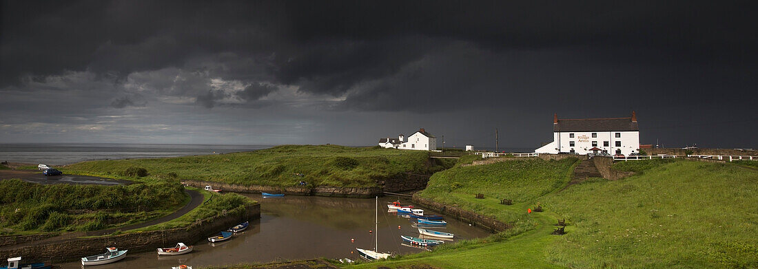 Dunkle Sturmwolken über einem Dorf an der Küste; Seaton Sluice Northumberland England