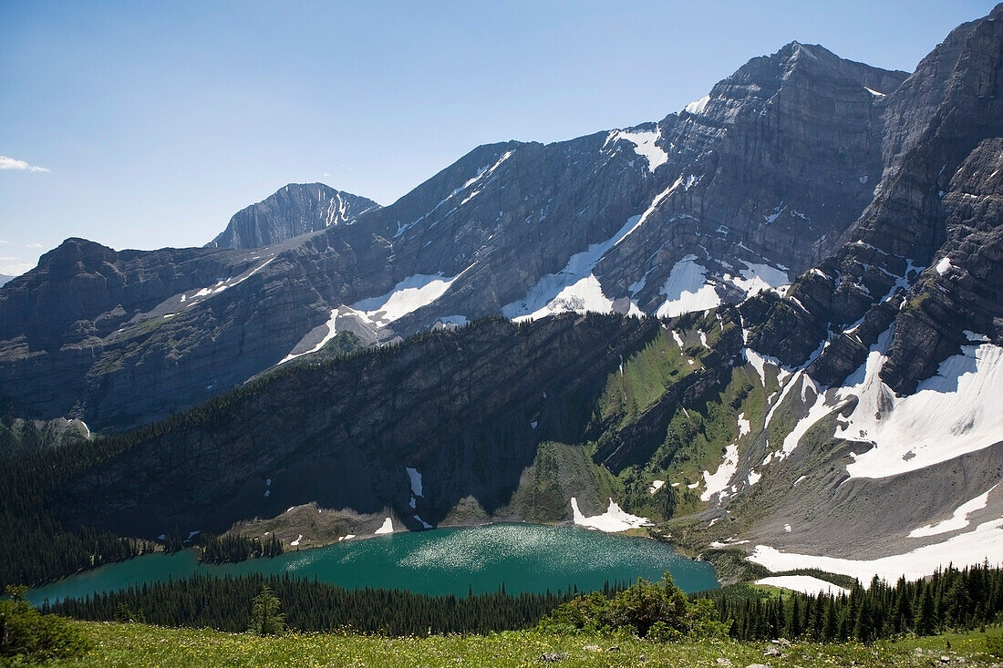 Bergsee umgeben von Bergen mit Schnee von einer Wildblumenwiese mit blauem Himmel; Kananaskis Provincial Park Alberta Kanada