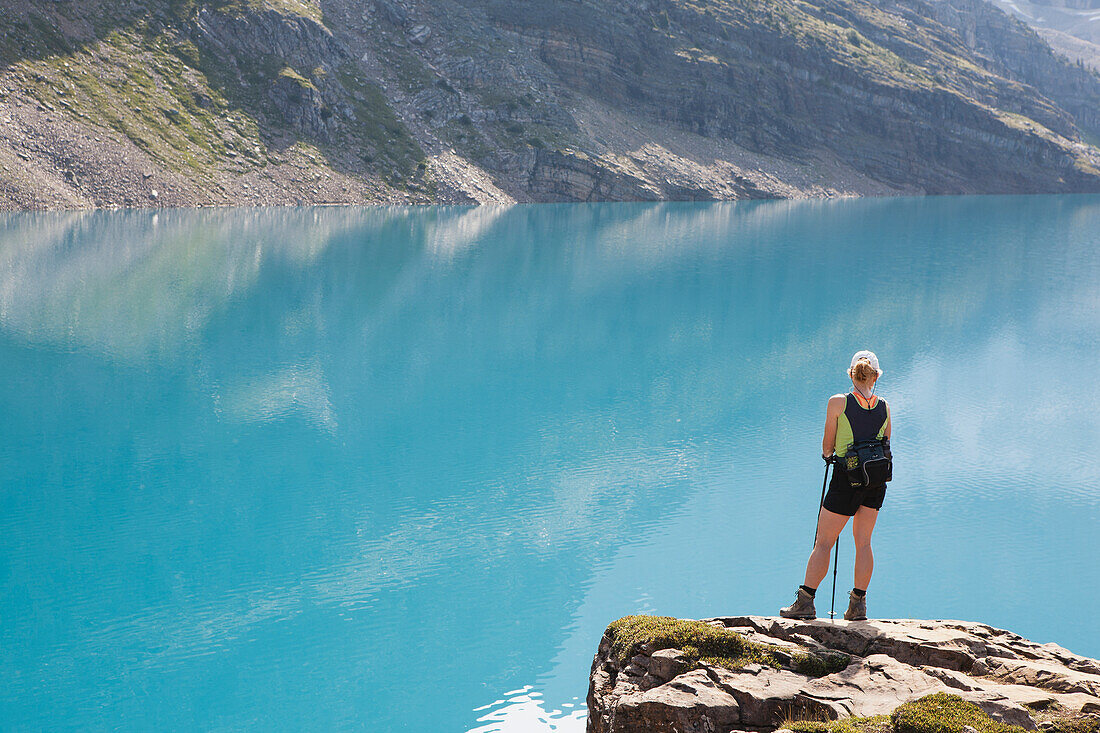Weibliche Wanderin auf Felsklippe mit Blick auf Bergsee; Feld British Columbia Kanada