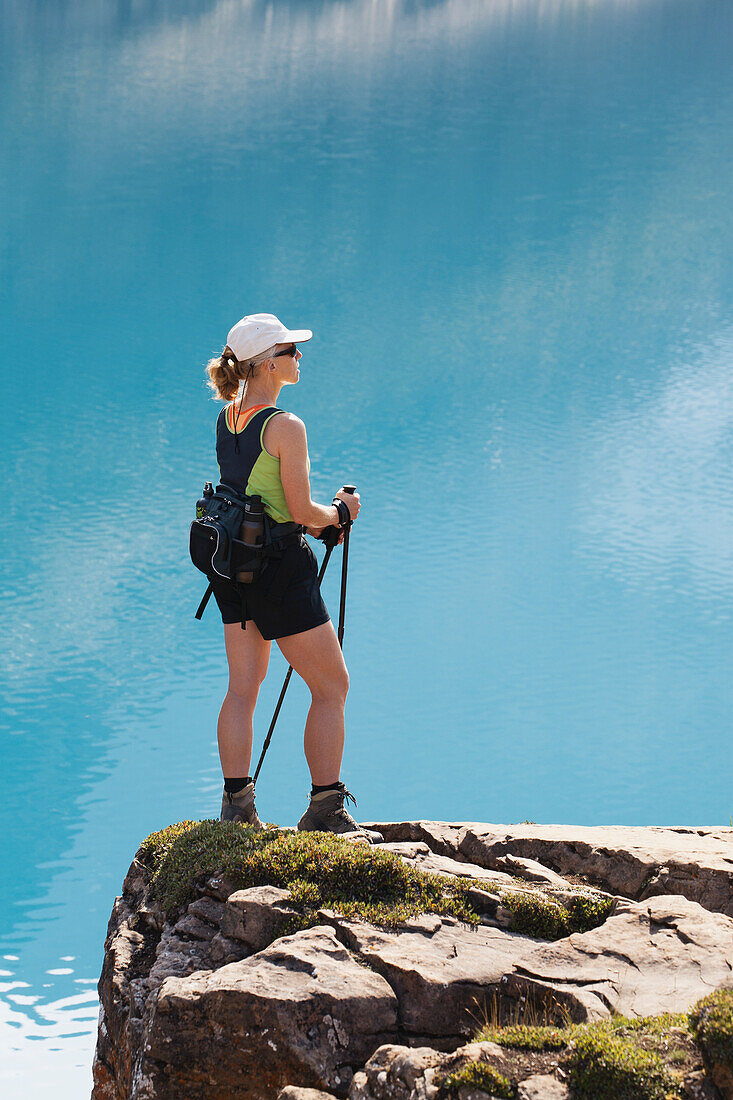 Female Hiker On Rock Cliff Overlooking Mountain Lake; Field British Columbia Canada