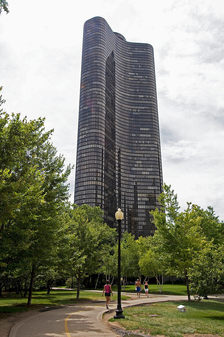 Fußgänger auf einem Weg in einem Stadtpark mit einem hohen Gebäude; Chicago Illinois Vereinigte Staaten Von Amerika