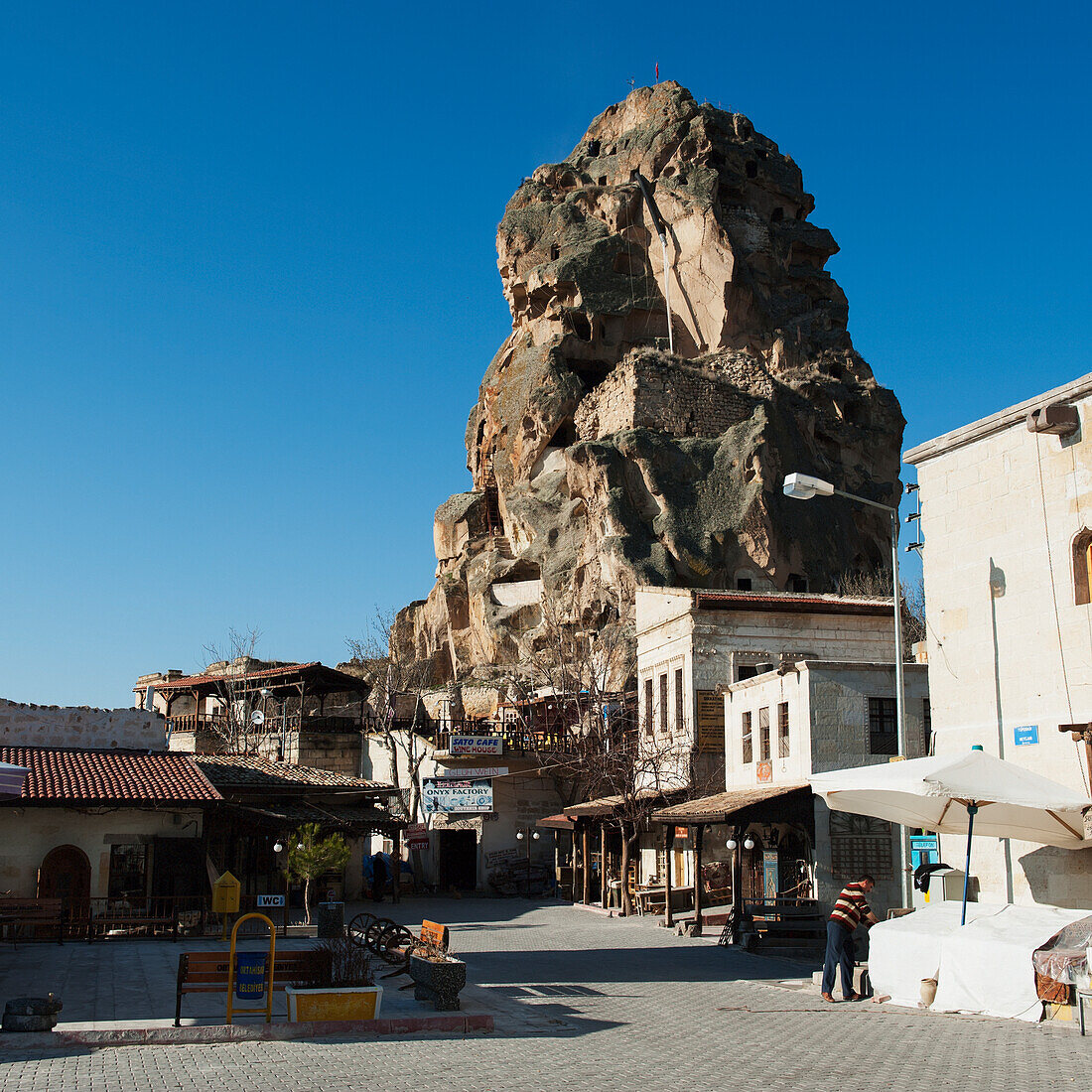 Eine große Felsformation (Burg von Ortahisar) gegen einen blauen Himmel in einem städtischen Gebiet; Ortahisar Nevsehir Türkei