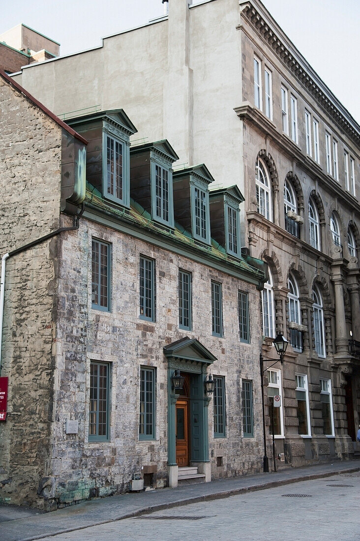 A Stone Building With Wooden Door And Loft Windows; Montreal Quebec Canada