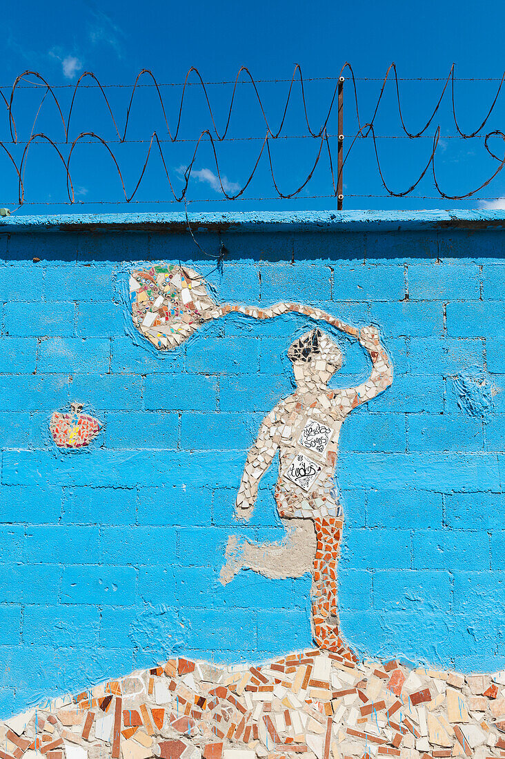 Ein Kachelmosaik mit einer menschlichen Figur, die ein Netz und einen Schmetterling an einer blauen Wand hält; Guatemala-Stadt Guatemala