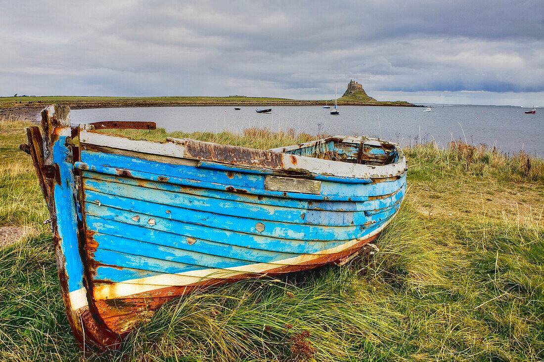Worn boat on shore; Lindisfarne, Northumberland, England, UK