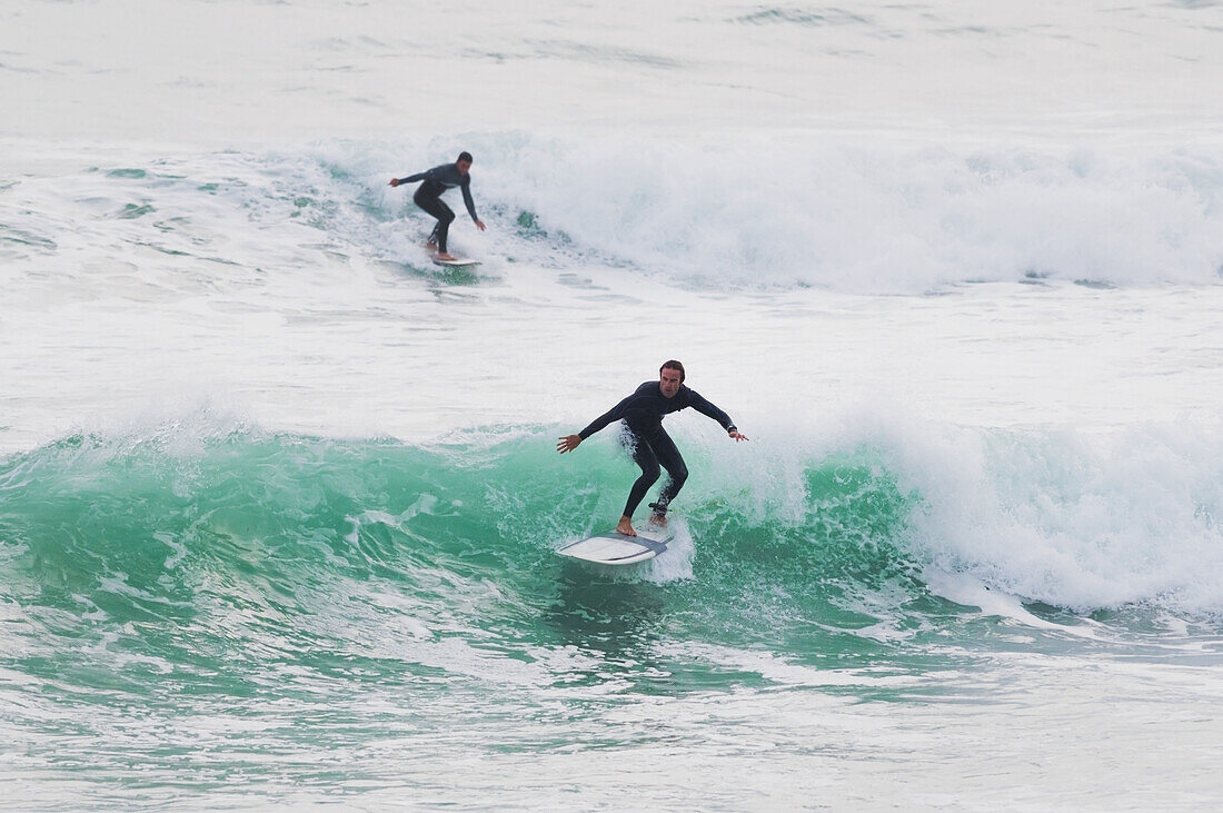 Surfers riding waves; Tarifa, Costa de la Luz, Cadiz, Andalusia, Spain