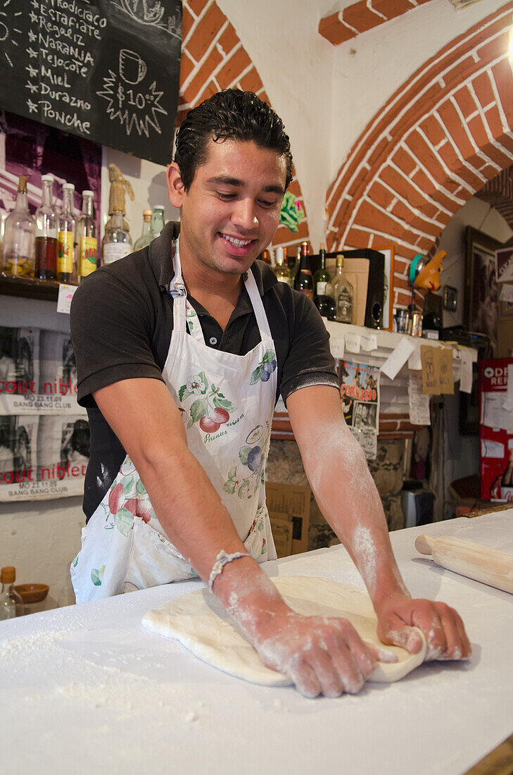 Mexico, Guanajuato State, Guanajuato, Young male baker making pizza dough