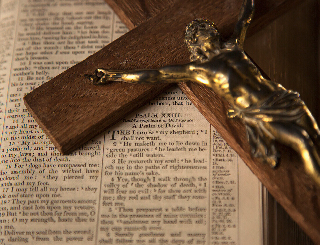 Hölzernes Kruzifix auf offener Bibel; Yetholm, Scottish Borders, Schottland, UK