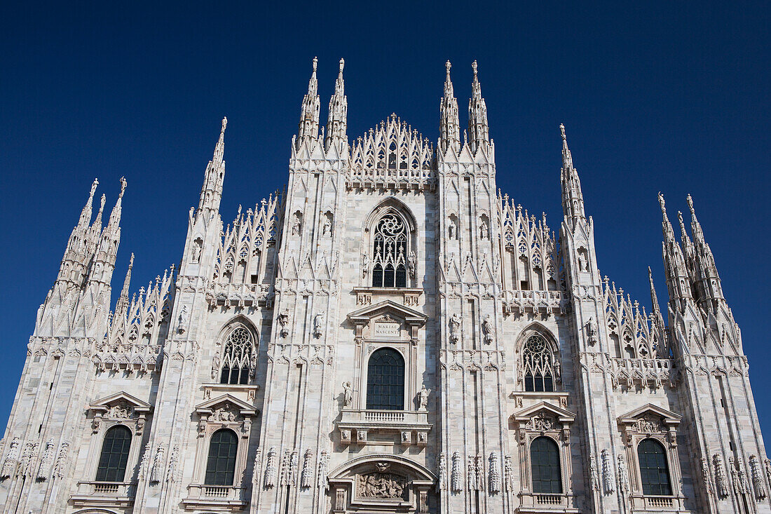 Italy, Lombardia, Milano, Marble facade of cathedral with blue sky