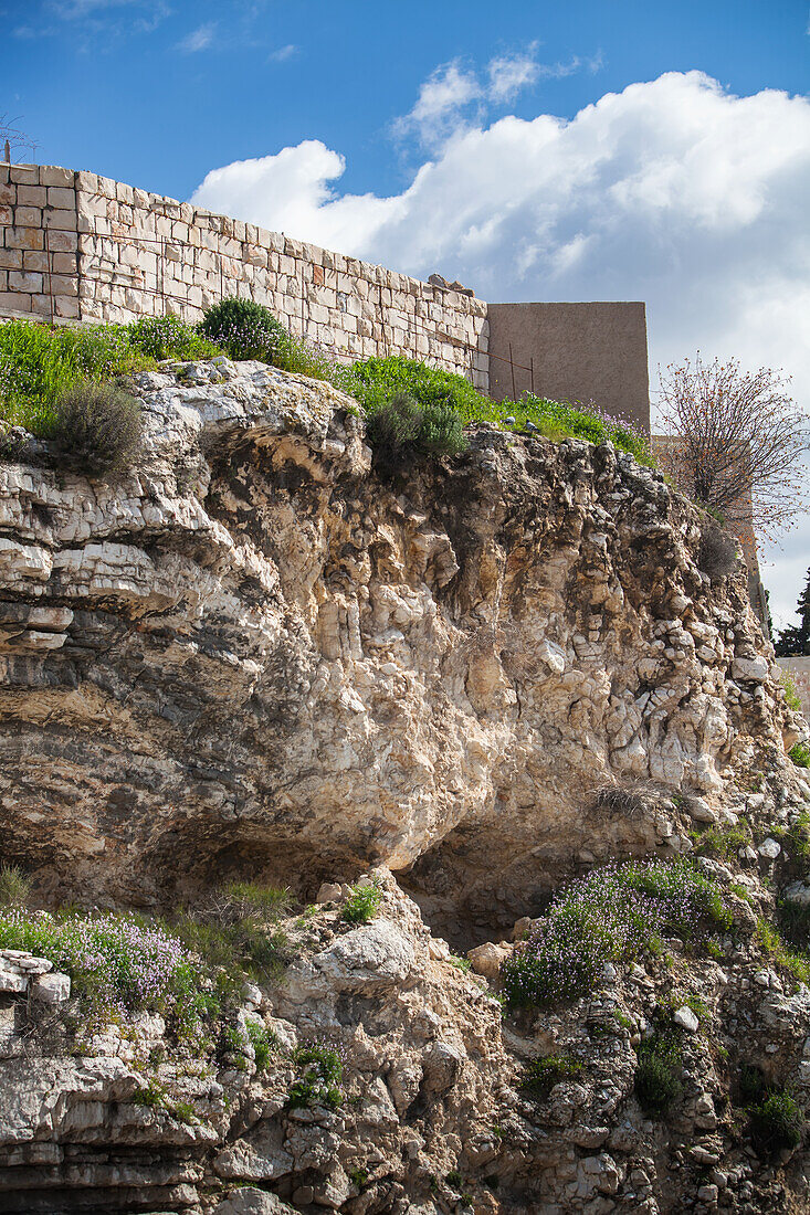 Israel, wo Jesus gekreuzigt wurde. In der Felsformation ist etwas zu sehen, das wie ein Schädel aussieht; Jerusalem, Schädelstätte, Kalvarienberg, Blick vom Gartengrabbereich, wo Jesus begraben wurde, auf Golgatha