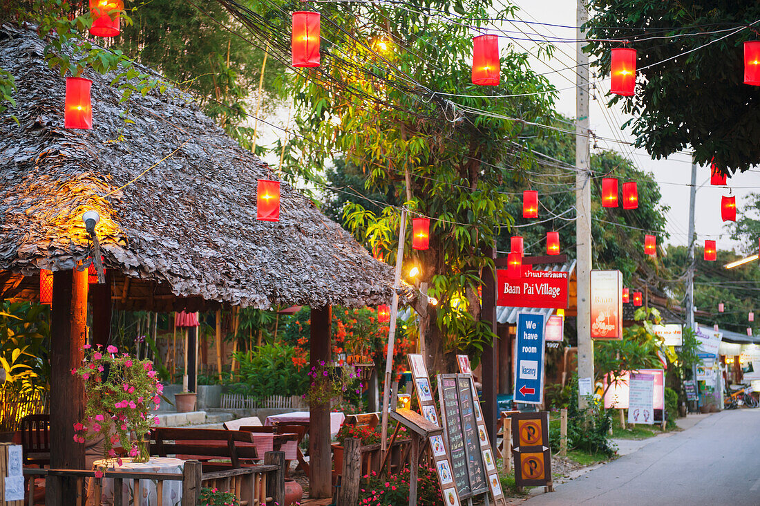 Thailand, Laternen hängen über einer mit Einzelhandelsgeschäften gesäumten Straße; Pai