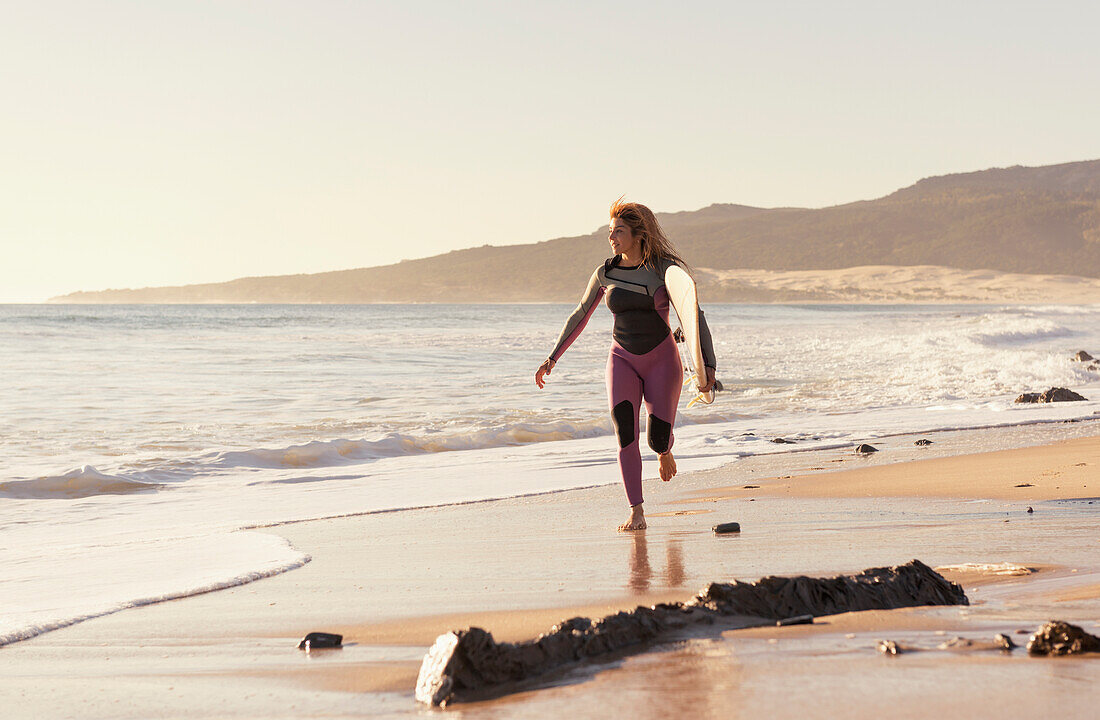 Spain, Andalusia, Cadiz, Costa de la Luz, Surfer on beach; Tarifa