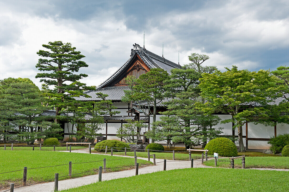 Japan, Spazierweg und Bäume vor traditioneller japanischer Architektur; Tokio