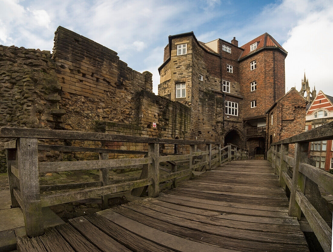 Eine hölzerne Promenade und ein Geländer vor einer alten Steinmauer; Newcastle, Tyne And Wear, England