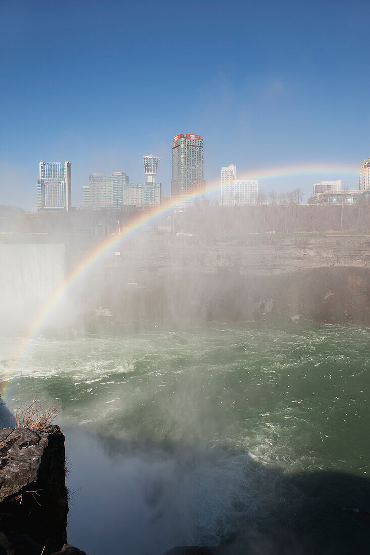 Ein Regenbogen über den Niagarafällen und der Schlucht mit Nebel und blauem Himmel; Niagara Falls, New York, Vereinigte Staaten Von Amerika