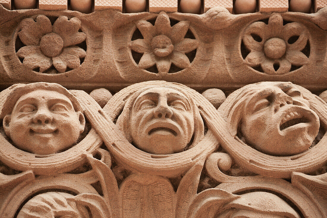 Close Up Of Stone Faces And Flowers On A Building; Toronto, Ontario, Canada
