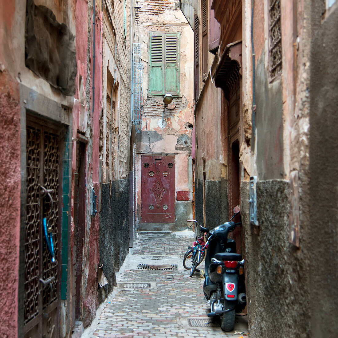 Motorcycle And Bicycle Parked In A Narrow Alley Outside Doorways; Marrakesh, Marrakech-Tensift-El Haouz, Morocco