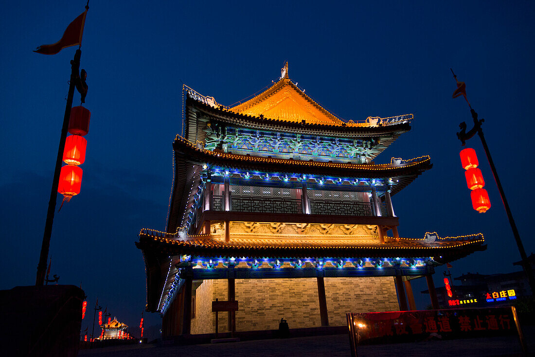 Ein beleuchtetes Gebäude bei Nacht entlang der alten Stadtmauer von Lianhu; Xi'an, Shaanxi, China