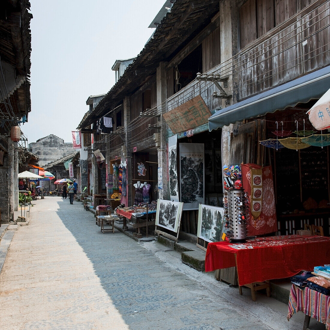 Geöffnete Geschäfte mit Tischen, die ihre Waren ausstellen; Yangshuo, Guangxi, China