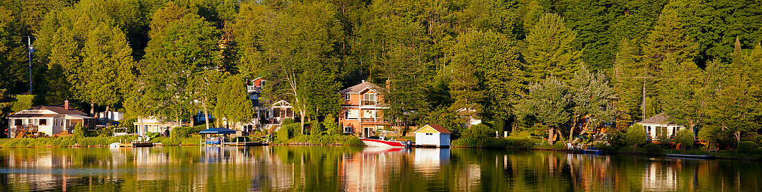 Cottages am Bowker Lake bei Sonnenuntergang; Quebec, Kanada