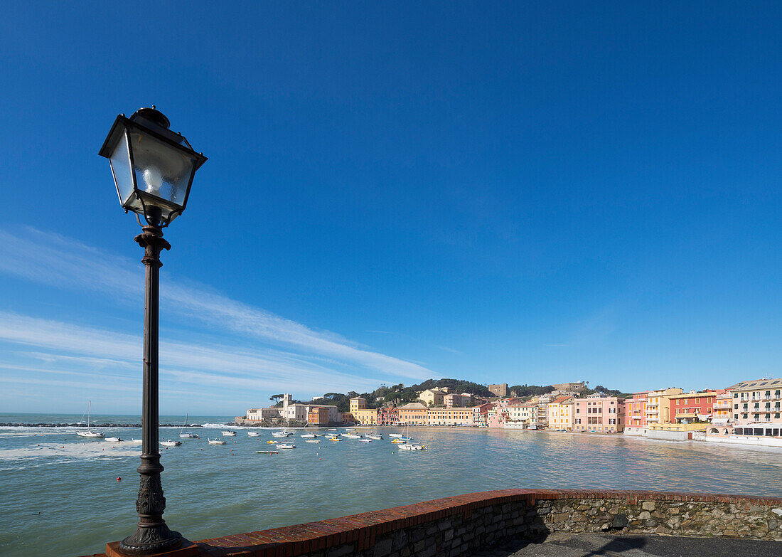 A Lampost Along The Water's Edge With Boats Mooring In The Harbour; Sestri Levante, Liguria, Italy