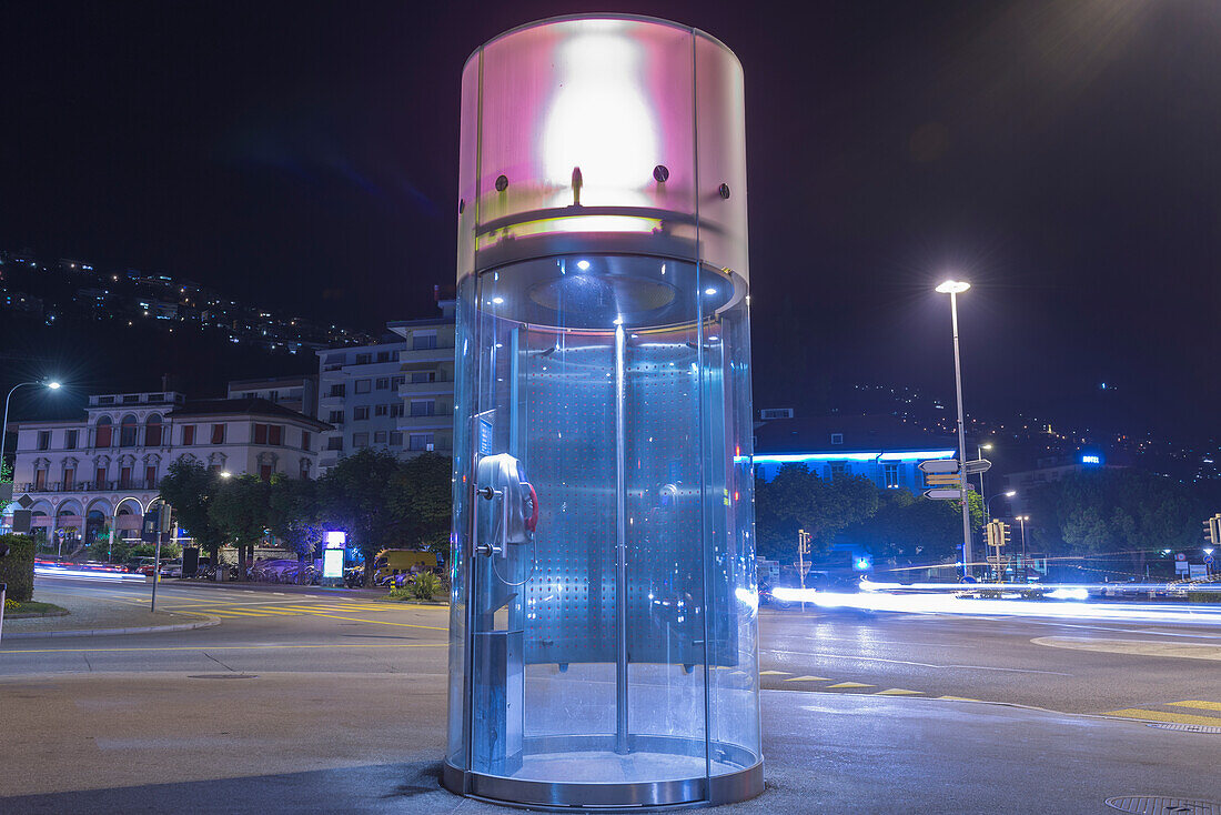 A Round Telephone Booth Illuminated At Nighttime; Locarno, Ticino, Switzerland