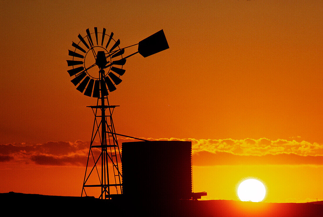 Windmühle und Wassertank, Silhouette bei Sonnenuntergang