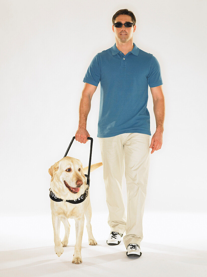 Mann geht mit Blindenhund spazieren