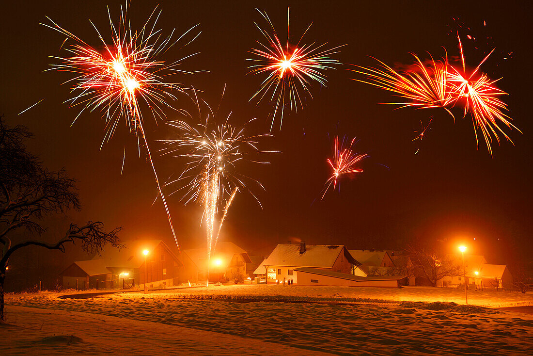 Silvesterfeiern mit Feuerwerk in einem Dorf, Bayern, Deutschland