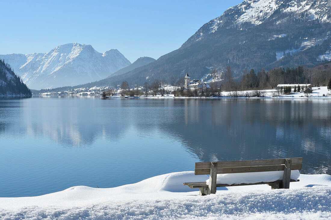 Landschaft mit verschneiter Bank am Grundlsee im Winter, Steiermark, Österreich