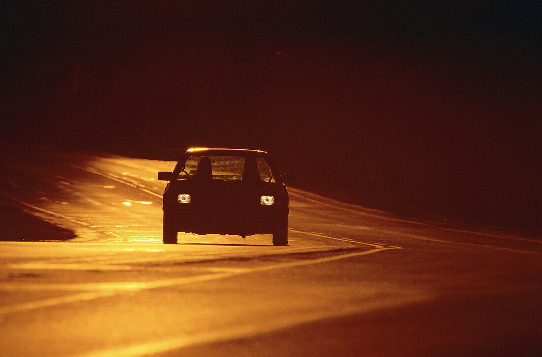 Auto auf Straße bei Sonnenuntergang