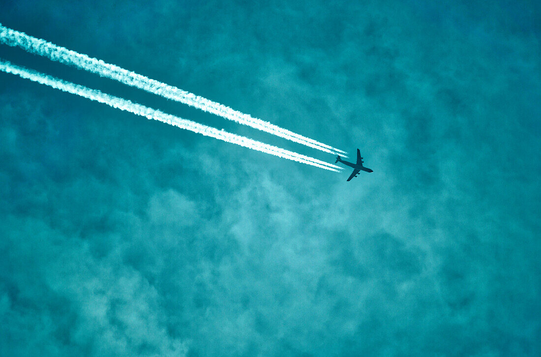 Flugzeug am Himmel mit Kondensstreifen