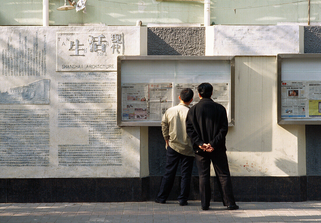 Männer schauen auf eine Informationstafel Shanghai, China