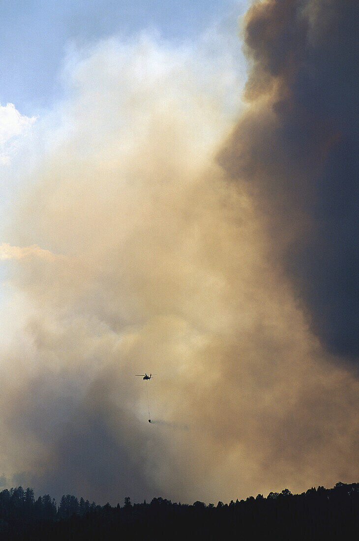 Rauch von einem Waldbrand mit Löschhubschrauber