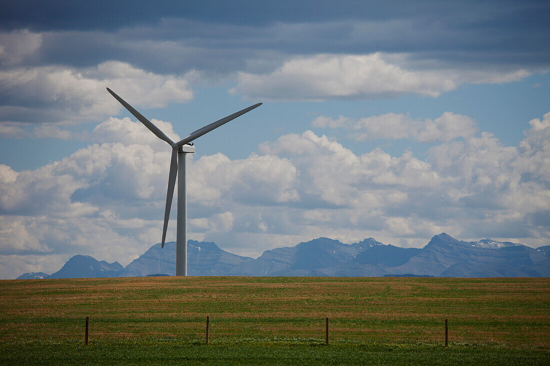Wind generators in field, mountain range in background, Montana, USA