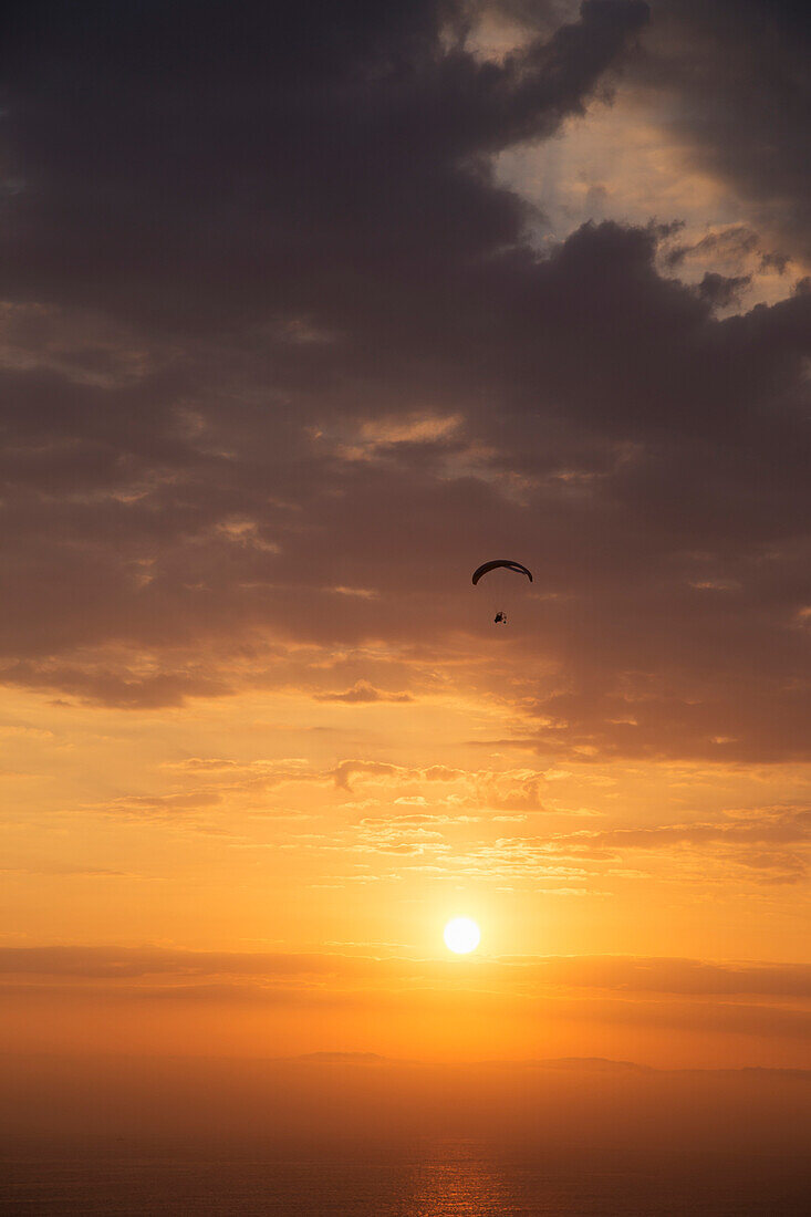 Silhouette von Parasailing bei Sonnenuntergang, Parque Raimondi entlang Malecon Cisneros, Miraflores, Lima, Peru