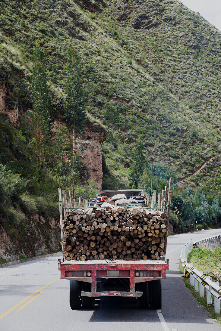 Rückansicht eines Holzfällerfahrzeugs auf einer Straße im ländlichen Peru