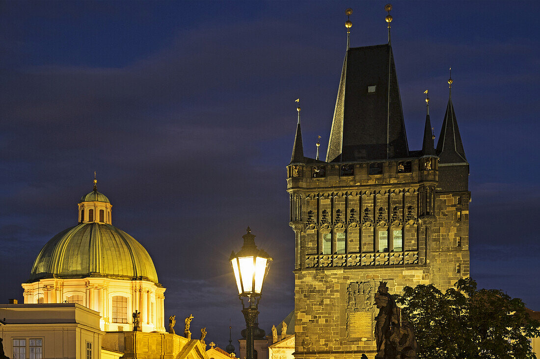 Rooftops of Church of St Francis Seraphinus and the Old Town Bridge Tower at night, Prague, Czech Republic