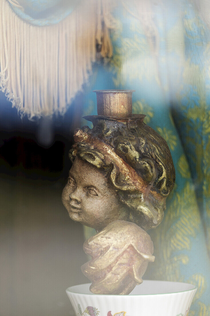 Angel candle holder sitting in window of building with fringed curtain at Barkerville Historic Town, British Columbia, Canada