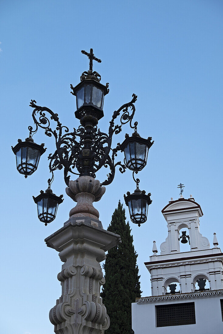 Laternenpfahl und Kirchenglocken in Sevilla, Andalusien, Spanien