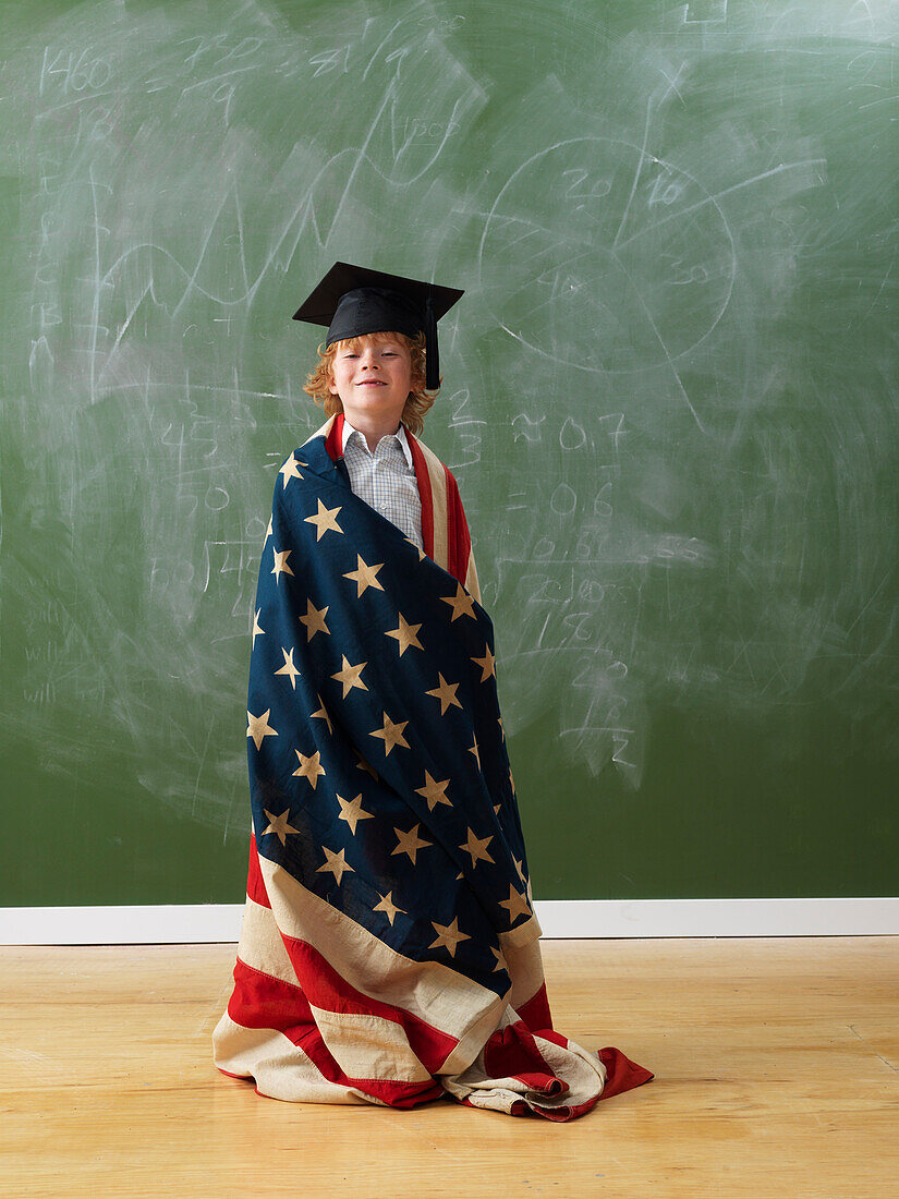 Junge trägt amerikanische Flagge und Abschlusshut