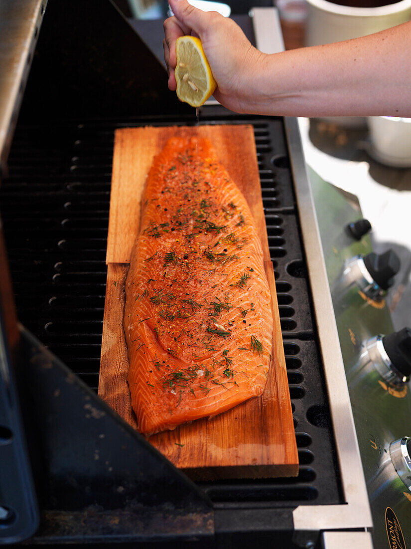 Mann bereitet Fisch auf dem Grill zu